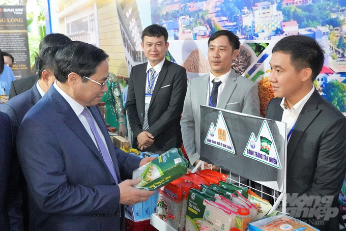 Thủ tướng Phạm Minh Chính (bìa trái) và anh Đặng Khánh Duy (bìa phải) trong một sự kiện xúc tiến thương mại xuất khẩu bánh tráng. 