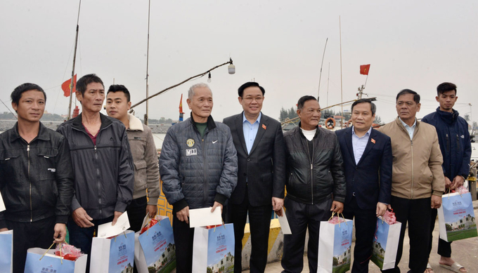 Chủ tịch Quốc hội Vương Đình Huệ tặng quà cho các ngư dân xã bảo Ninh. Ảnh: TP.
