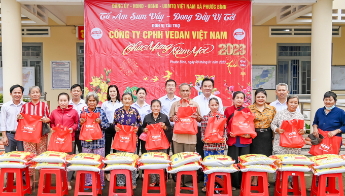 Bà Nguyễn Thu Thủy - Phó Giám đốc Đối ngoại Vedan Việt Nam (áo cam) đến trao quà Tết cho người dân tại xã Phước Bình.