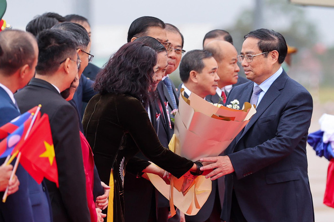 Thủ tướng nhận hoa từ đại diện cộng đồng Việt Nam tại Lào. Ảnh: Nhật Bắc.
