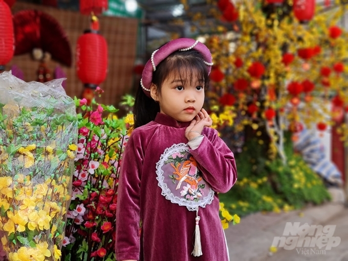 Các em nhỏ cũng thỏa sức tạo dáng chụp ảnh trên phố hoa ngày Tết ở thành phố Tuyên Quang.