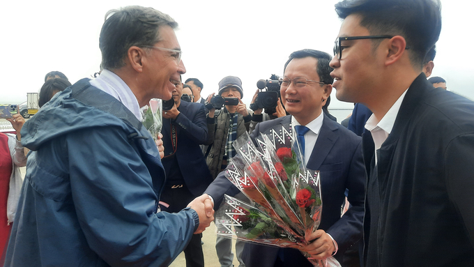 Ông Cao Tường Huy tặng hoa cho đoàn khách du lịch. Ảnh: Nguyễn Thành.