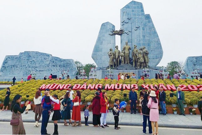 Du khách chụp ảnh lưu niệm tại tượng đài Bác Hồ với người dân Quảng Bình. Ảnh: TP.