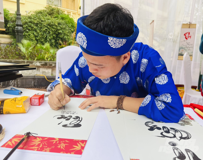 Một thầy đồ đang viết chữ thư pháp. Ảnh: Toán Nguyễn.