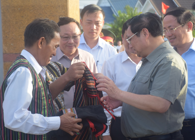 Thủ tướng Phạm Minh Chính được già làng tặng áo truyền thống của dân tộc Hrê. Ảnh: V.Đ.T.