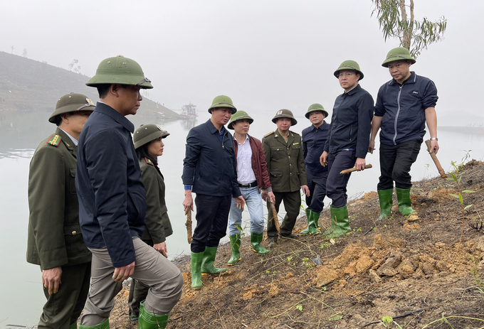 Chủ tịch UBND tỉnh Yên Bái Trần Huy Tuấn (thứ tư từ trái sang) cùng lãnh đạo huyện Yên Bình tham gia trồng cây. Ảnh: Tuấn Anh.