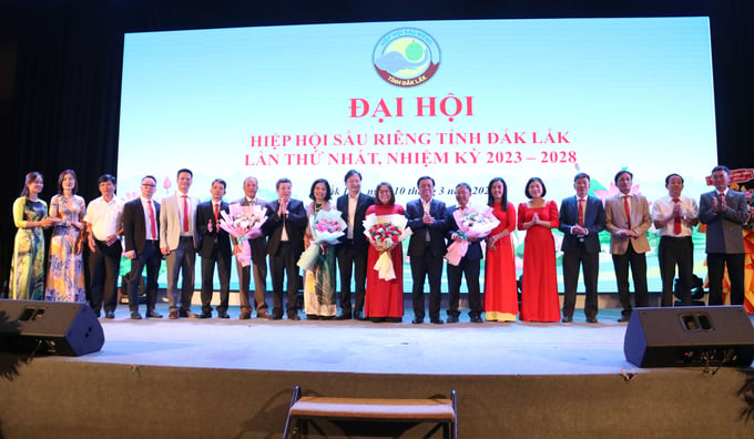 Bộ trưởng Lê Minh Hoan cùng đại biểu tặng hoa Ban chấp hành Hiệp hội Sầu riêng tỉnh Đắk Lắk khóa I, nhiệm kỳ 2023 - 2028. Ảnh: Quang Yên.