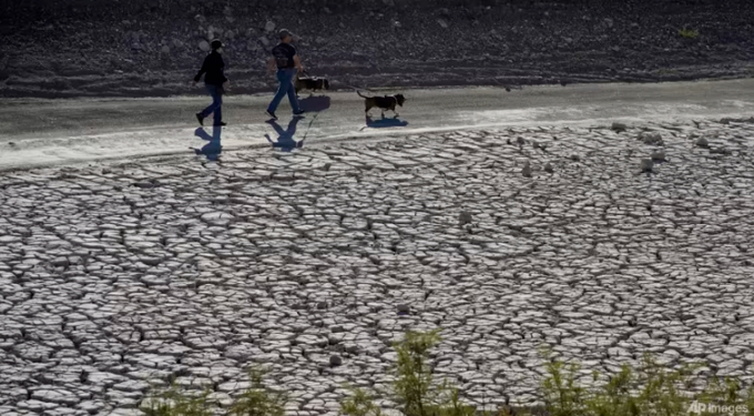 People walk by cracked earth in an area once under the water of Lake Mead at the Lake Mead National Recreation Area, on Jan 27, 2023, near Boulder City, Nevada. Photo: AP/John Locher