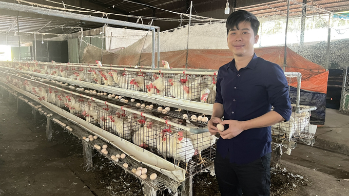 Anh Hà bên trại gà đẻ trứng hồng của mình tại xã Thanh An. Ảnh: Minh Sáng.