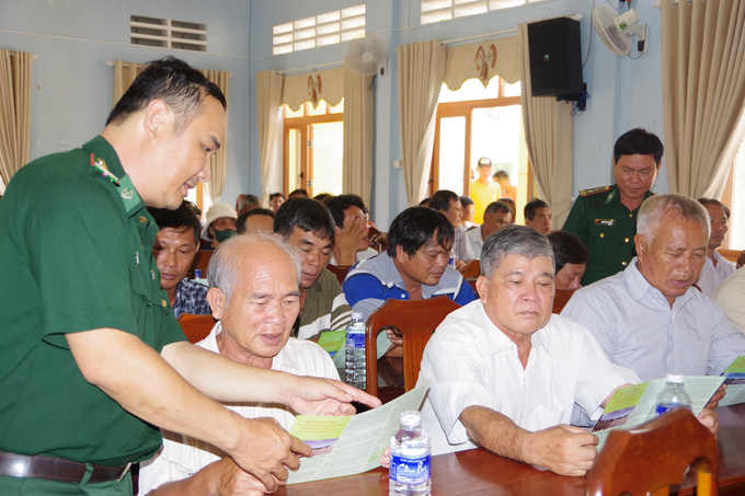 Cán bộ Đồn Biên phòng Cát Khánh (huyện Phù Cát, Bình Định)  tuyên truyền pháp luật cho ngư dân. Ảnh: Đ.T.
