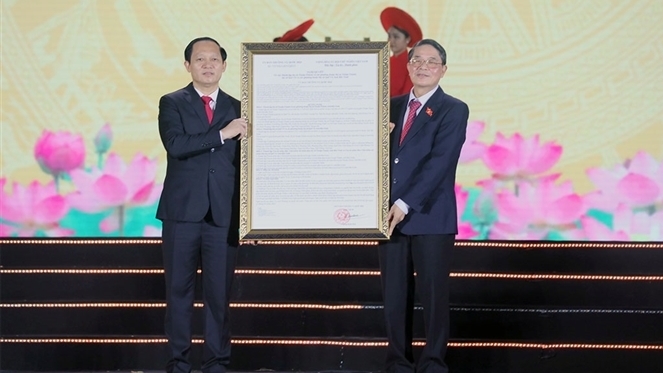 Phó Chủ tịch Quốc hội Nguyễn Đức Hải (bên phải) trao Nghị quyết của Ủy ban Thường vụ Quốc hội cho Đảng bộ, chính quyền thị xã Quế Võ và các phường thuộc thị xã Quế Võ. Ảnh: Nguyên Thành.