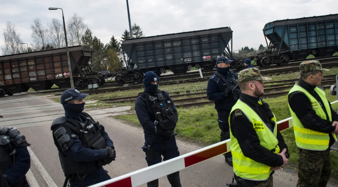 Policemen and border guards protect a train carrying Ukrainian grain at the broad-gauge railway line crossing in Hrubieszow, Poland, on April 12, 2023. Photo: Attila Husejnow/SOPA Images/LightRocket/Getty Images