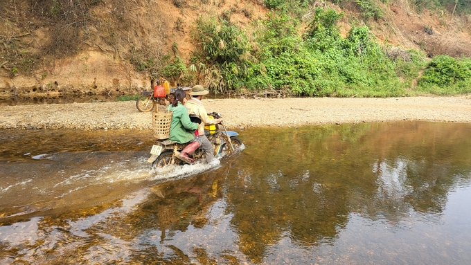 Không có cầu, người dân liều mình băng qua suối vào khu sản xuất. Ảnh: Tuấn Anh.