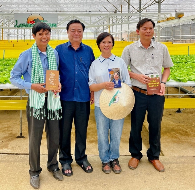 Bộ trưởng Bộ NN-PTNT Lê Minh Hoan tặng sách cho các thành viên trang trại Lang Biang Farm ở TP Đà Lạt, tỉnh Lâm Đồng. Ảnh: Trần Văn Tân.