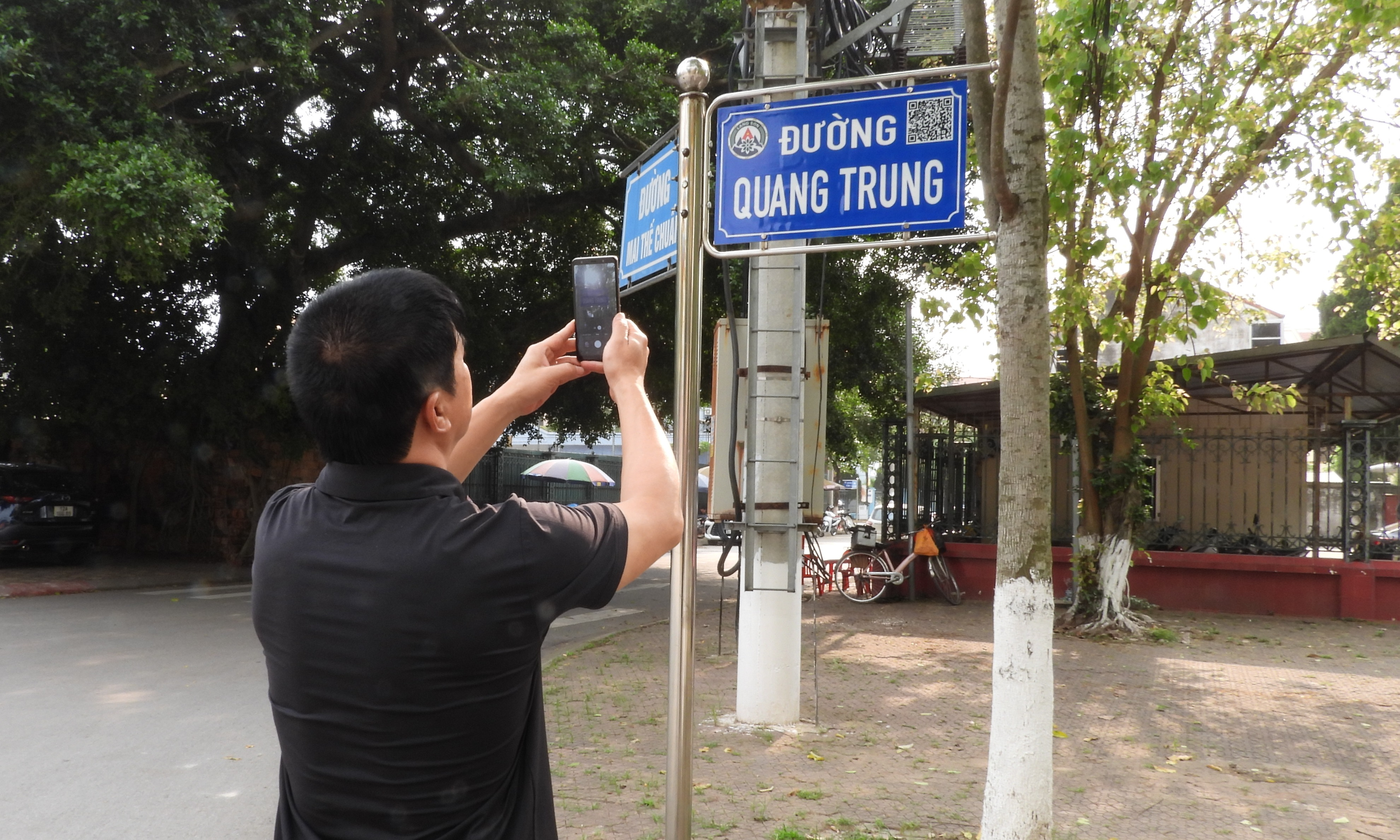 Người dân quét mã QR tra cứu thông tin từ các biển tên đường phố ở Lạng Sơn. Ảnh: Tùng Đinh.