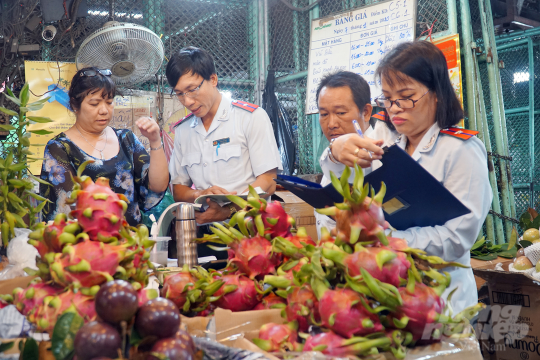 Kiểm tra an toàn thực phẩm tại chợ đầu mối. Ảnh: Nguyễn Thủy.