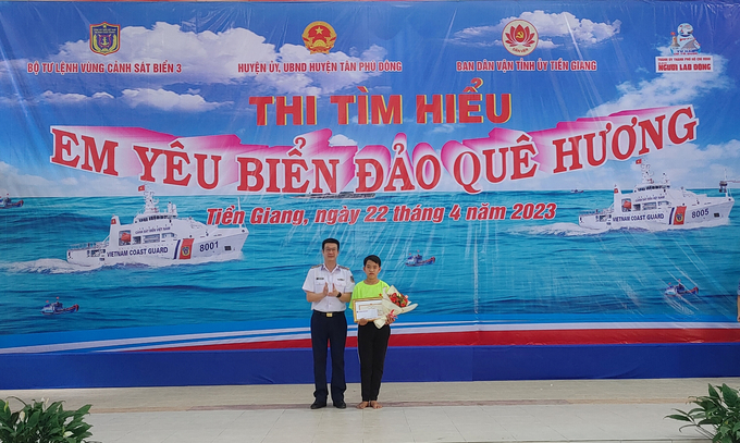 Đại tá Nguyễn Minh Khánh trao giải nhất cho em Trần Văn Lộc tại cuộc thi tìm hiểu 'Em yêu biển đảo quê hương'.
