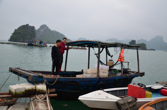 Những đứa cháu của anh Nguyễn Văn Thành bên chiếc mủng chở cá mồi về nuôi cá. Ảnh: Tiến Thành.