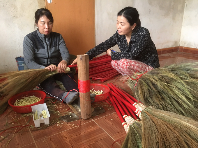 Chị Nhung (phải) tận tình hướng dẫn cho chị em kỹ thuật làm chổi đót. Ảnh: Việt Toàn.