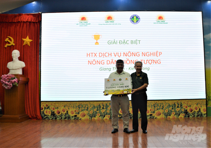 Ông Huỳnh Văn Thòn (phải), Chủ tịch HĐQT Tập đoàn Lộc Trời trao giải đặc biệt là 1 lượng vàng SJC cho HTX Dịch vụ nông nghiệp Giồng Tượng (Kiên Giang) với kết quả thu gom được hơn 2 tấn bao bì thuốc BVTV. Ảnh: Trung Chánh.