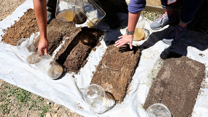 Different types of soil are examined after being exposed to a rainwater test during the Soil Health Academy, which teaches regenerative agriculture techniques, in Cimarron, New Mexico on May 31, 2022. Photo:  Mario Tama via Getty Images