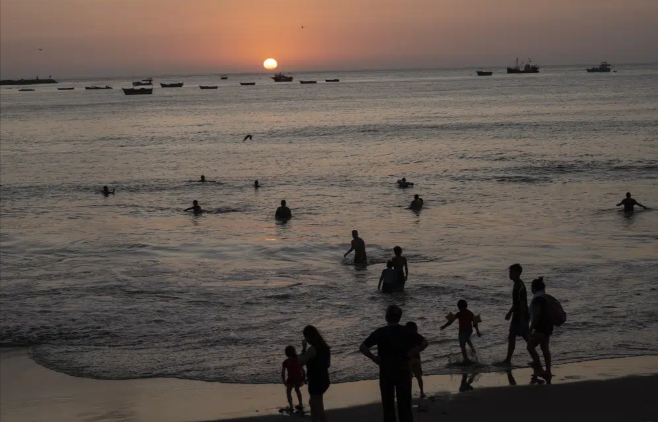 People bathe in the Pacific Ocean at Agua Dulce beach at sunset in Lima, Peru, Feb. 8, 2023. The world's oceans have suddenly spiked much hotter and well above record levels, with scientists trying to figure out what it means and whether it forecasts a surge in atmospheric warming. Photo: Rodrigo Abd/AP