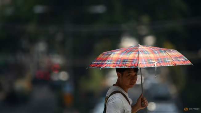 A man holds up an umbrella as temperatures hit a record 45.4 degrees Celsius in Bangkok, Thailand, April 21, 2023. Photo: Reuters/Athit Perewongmetha