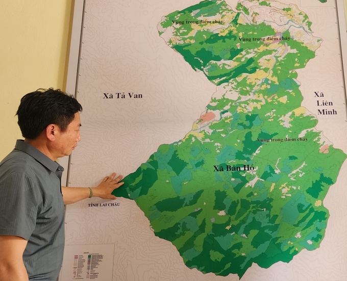 Chủ tịch xã Lý Láo Tả và bản đồ toàn màu xanh của xã Bản Hồ. Ảnh: Văn Việt. 