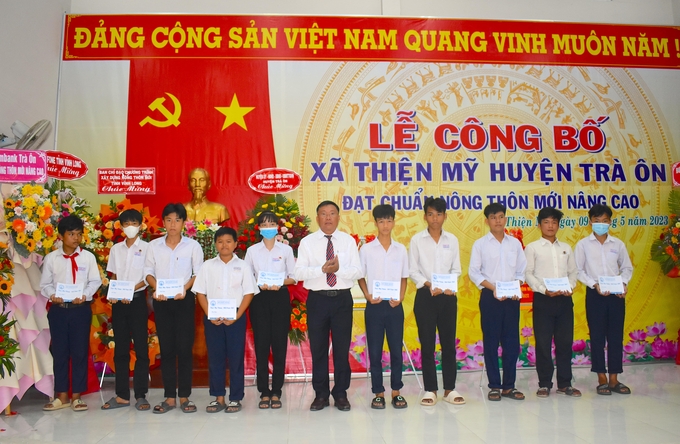 UBND huyện Trà Ôn tặng học bổng cho các em học sinh xã Thiện Mỹ. Ảnh: Minh Đảm.