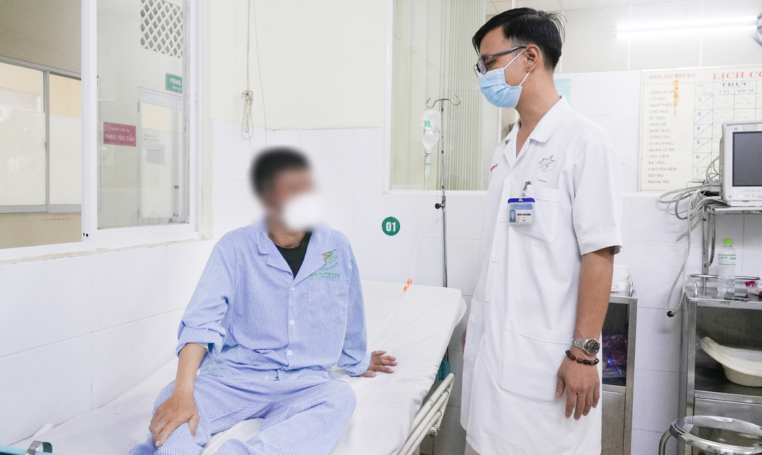 Thiếu tá, BS.CK1 Dương Xuân Minh, Khoa lọc máu, Bệnh viện Quân Y 175 kiểm tra sức khỏe cho bệnh nhân bị ngộ độc rượu Methanol. Ảnh: Bệnh viện cung cấp.