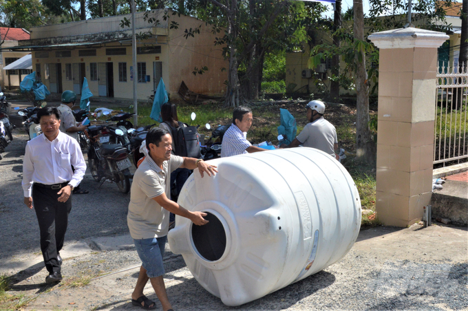 Bà con xã Xà Phiên nhận bồn chứa nước do chương trình tặng và háo hức mang về nhà. Ảnh: Trung Chánh.