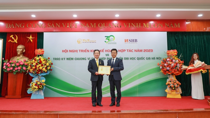 GS.TS Lê Quân (bên phải) trao kỷ niệm chương vì sự nghiệp phát triển ĐHQG HN cho doanh nhân Đỗ Quang Hiển. 