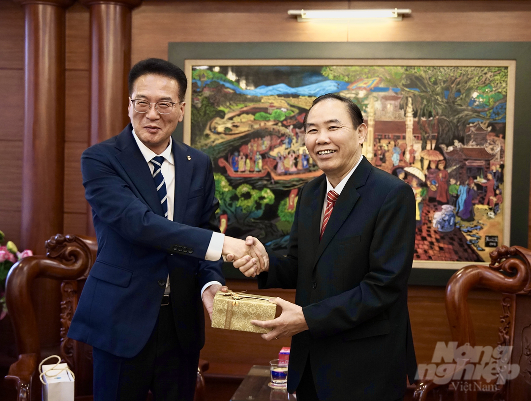Ông Chang An Cheol (ảnh trái) tặng quà lưu niệm cho Thứ trưởng Phùng Đức Tiến. Ảnh: Linh Linh.
