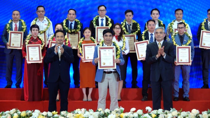 Ông Lê Minh Mân, Phó Tổng Giám đốc Công ty TNHH Woosung Việt Nam (đứng giữa) đại diện doanh nghiệp đón nhận giải thưởng Top 500 doanh nghiệp tăng trưởng nhanh nhất Việt Nam. Ảnh: Quang Linh.