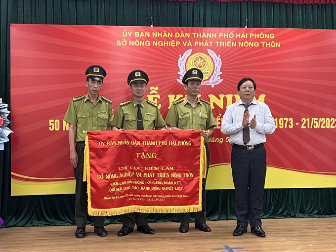 Ông Nguyễn Đức Thọ - Phó Chủ tịch UBND TP Hải Phòng trao tặng cờ, ghi nhận những đóng góp của lực lượng kiểm lâm cho sự phát triển kinh tế - xã hội của TP Cảng thời gian qua. Ảnh: Đinh Mười. 