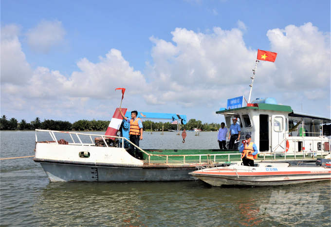 Lực lượng chức năng ra hiệu lệnh cho tàu dừng lại, neo đậu để chờ phân luồng, điều tiết lưu thông thủy qua âu thuyền của cống Cái Lớn. Ảnh: Trung Chánh.