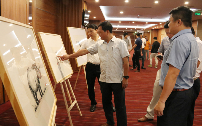 Seminar participants viewing sketches of wild animals with the theme of 'Save wildlife save our life'. Photo: Quang Yen.