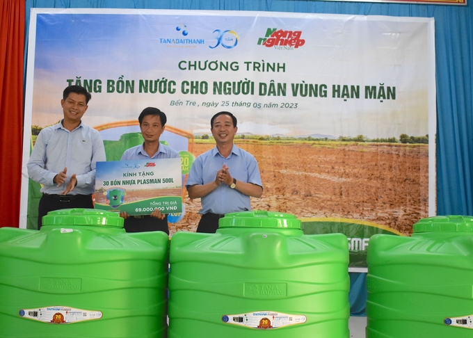 Trao bảng tượng trưng tặng 30 bồn chứa nước san sẻ khó khăn với bà con xã Vĩnh Hòa, huyện Chợ Lách. Ảnh: Minh Đảm.