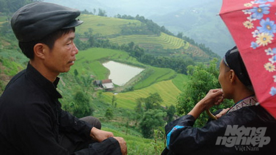 Chàng trai Nùng Sín Văn Tinh, bản Thèn Phàng và tác phẩm thửa ruộng bậc thang hình trái tim do anh tạo tác. Ảnh: Kiên Trung.