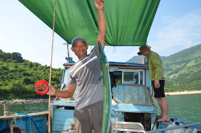 Le Van Tho shows off his newly caught fish. Photo: Cong Dien.