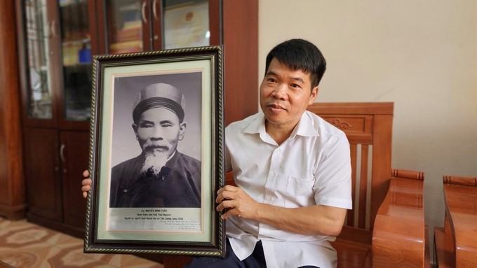 Secretary of the Party Committee, Chairman of the Tan Cuong People's Committee, with a photo of Mr. Nguyen Dinh Tuan. Photo: Hoang Anh.