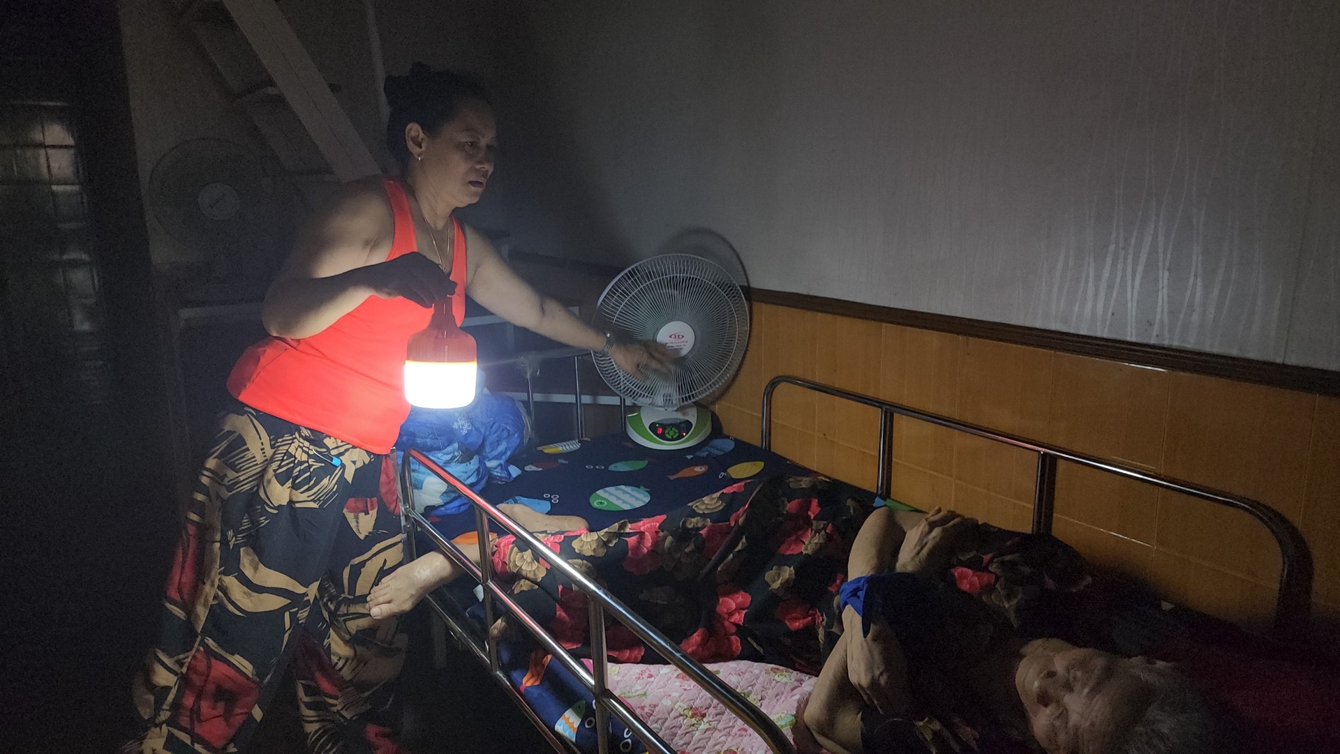 Chị Thanh Bình mua vội chiếc quạt tích điện về để phục vụ mẹ già đang ốm. Ảnh: Đinh Mười.