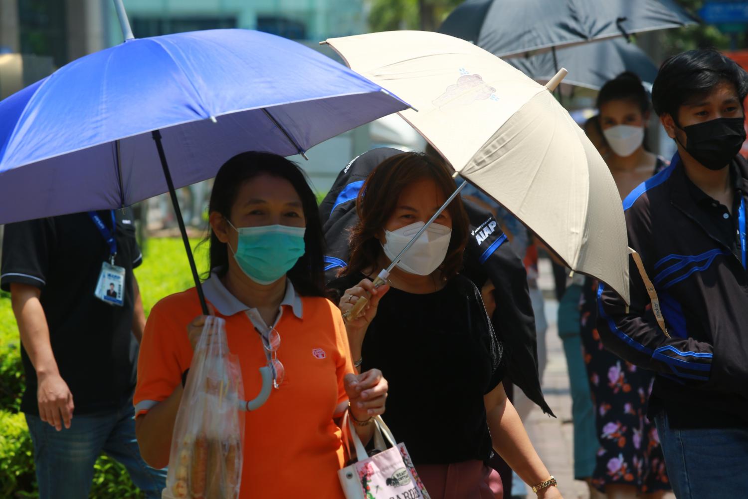 Người dân quận Bang Na, 1 trong 50 đơn vị hành chính của Thủ đô Bangkok, che ô dưới cái nóng như thiêu đốt buổi trưa.