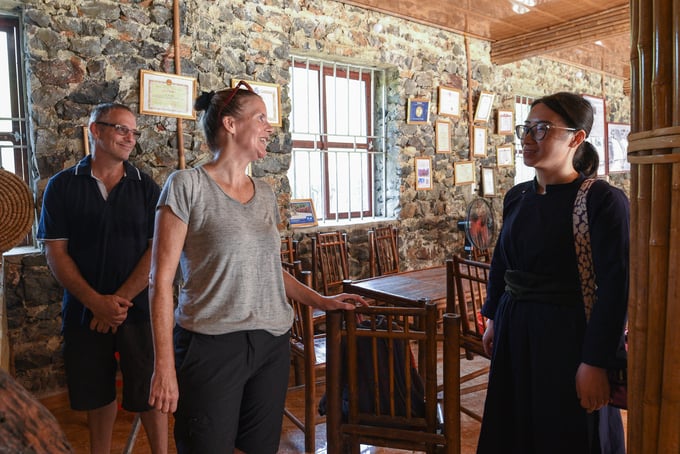 Nữ thạc sỹ người Tày giúp 2 du khách Australia giao tiếp, tìm hiểu thông tin di chuyển khi họ đến thăm xã Đàm Thủy, huyện Trùng Khánh. Ảnh: Tùng Đinh.