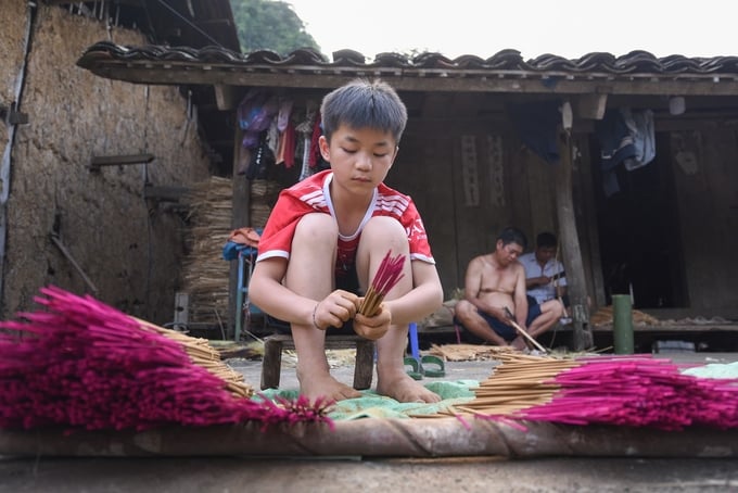 Những em nhỏ trong làng Phja Thắp phụ giúp gia đình, giữ gìn nghề truyền thống. Ảnh: Tùng Đinh.