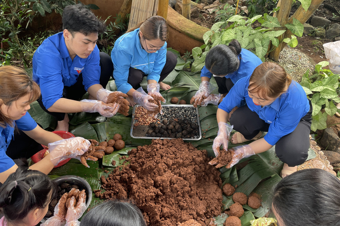 Các tình nguyện viên làm 'bom hạt giống' trong mô hình vườn rừng. Ảnh: Quang Yên.