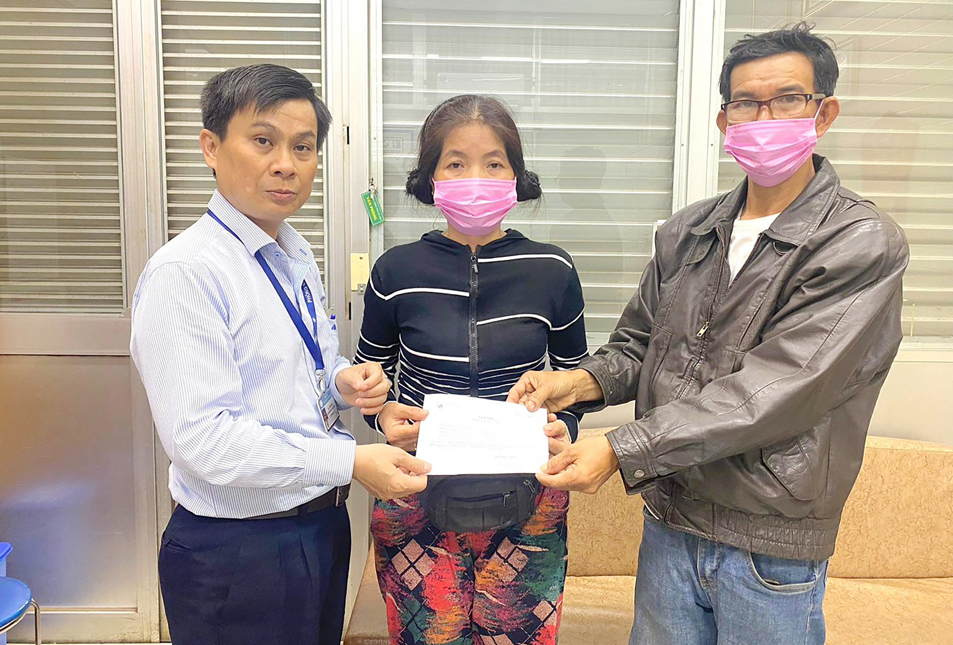 ThS Lê Minh Hiển, Trưởng phòng Công tác xã hội, Bệnh viện Chợ Rẫy trao số tiền các mạnh thường quân hỗ trợ cho gia đình bệnh nhân ngộ độc botulinum. Ảnh: BVCC.