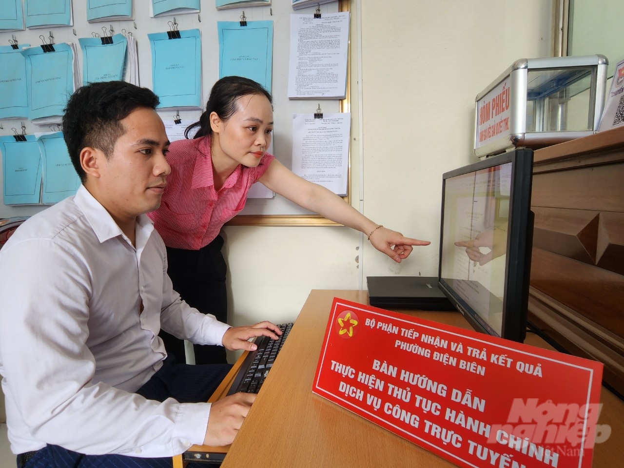 Người dân được cán bộ phường Điện Biên hướng dẫn tận tình khi thực hiện thủ tục hành chính dịch vụ công trực tuyến. Ảnh: Quốc Toản.