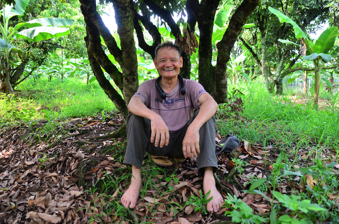 Lão nông Nguyễn Văn Khương 70 tuổi ngồi khoan thai nghỉ dưới gốc vải. Ảnh: Dương Đình Tường. 
