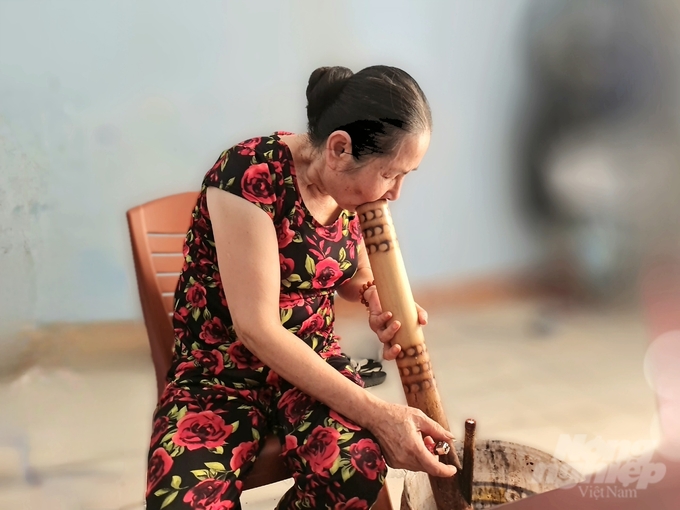 Bà Nguyễn Thị Minh Lý bảo, ở vùng cao muốn dân vận tốt phải biết uống rượu, riêng bà ngoài uống rượu còn biết hút thuốc lào. Ảnh: Đào Thanh.